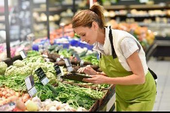 Medewerker in groentewinkel met i-pad in de hand