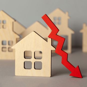 Houten huisje met een rode pijl langs het huis die naar beneden wijst